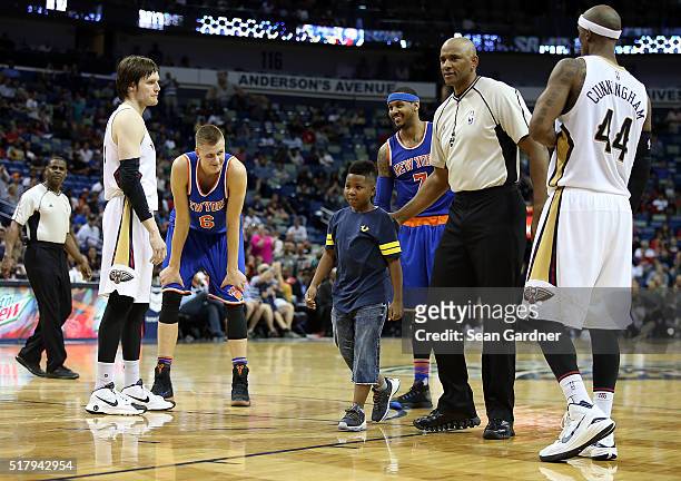 Young boy is escorted off the court after hugging Carmelo Anthony of the New York Knicks during a game against the New Orleans Pelicans during the...