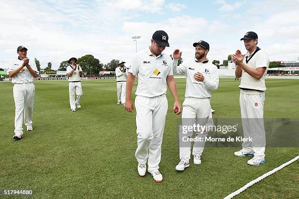 Jon Holland of the VIC Bushrangers is congratulated by teammates as Victorian players come from the field after South Australia was all bowled out...