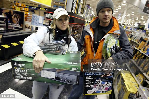 Tara Jackson and Tim Burnette both of Hebron, Indiana, wait at the checkout line inside a Best Buy electronics store November 26, 2004 in Hobart,...