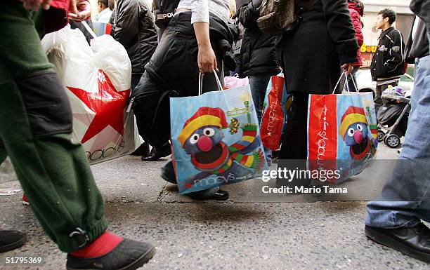 Shoppers carry bags outside Macy's department store November 26, 2004 in New York City. The Friday after Thanksgiving, called "Black Friday," is one...