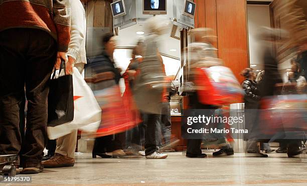 Shoppers carry bags inside Macy's department store November 26, 2004 in New York City. The Friday after Thanksgiving, called "Black Friday," is one...