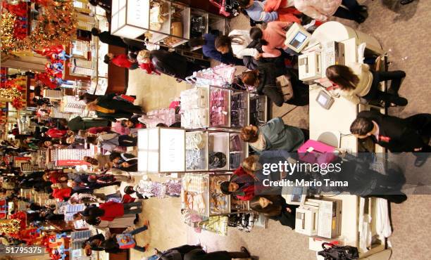 People shop in Macy's department store November 26, 2004 in New York City. The Friday after Thanksgiving, called "Black Friday," is one of the...