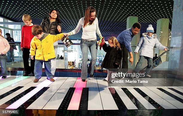 People play on a giant keyboard inside FAO Schwarz, the day after its grand re-opening November 26, 2004 in New York City. The Friday after...