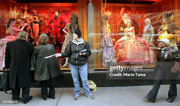 Woman passes out fliers in front of the Bloomingdale's holiday window display November 26, 2004 in New York City. The Friday after Thanksgiving,...