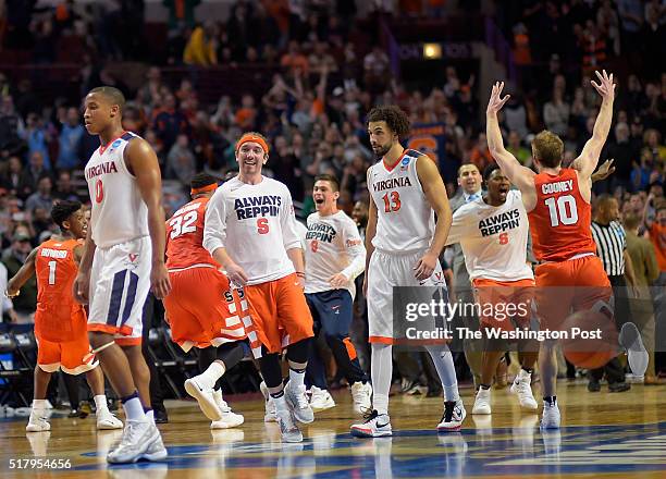 Virginia guard Devon Hall , left, and Virginia forward Anthony Gill center, walks off the floor after Syracuse defeats Virginia 68 -62 to win the...