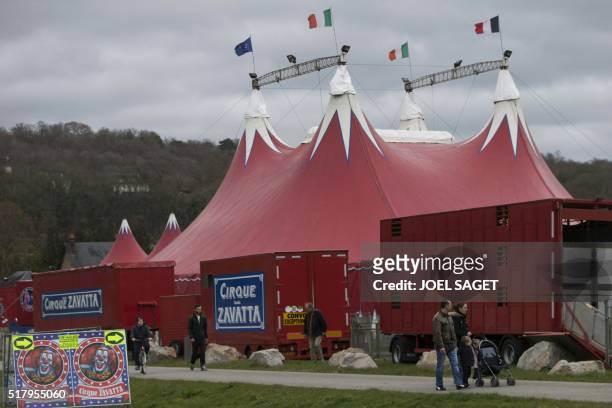People walk by the entrance to the Zavatta Circus in Pont-Audemer on March 26, 2016.