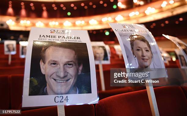 Seat markers with faces of nominees are seen in position during the 'heads on sticks' photocall ahead of the Olivier Awards, which takes place on...