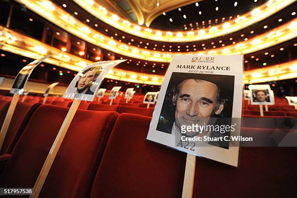 Seat markers with faces of nominees are seen in position during the 'heads on sticks' photocall ahead of the Olivier Awards, which takes place on...