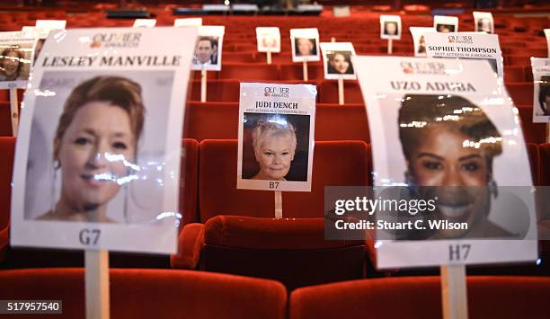 Seat markers with faces of nominees are seen in position during the 'heads on sticks' photocall ahead of the Olivier Awards, which takes place on...