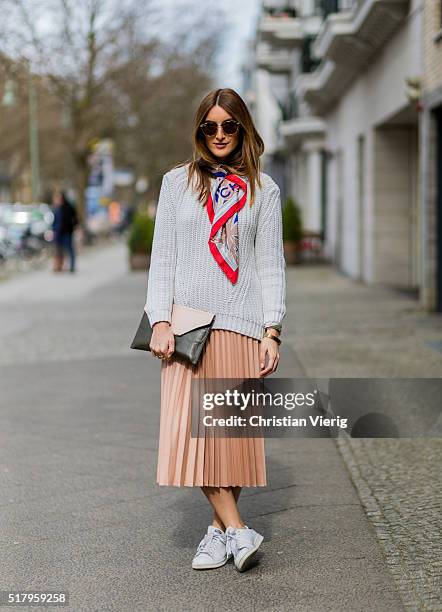 Fashion blogger Sofia Grau is wearing a salmon pink skirt from Zara, white sneakers from Adidas, a grey sweater from Mango, a pink black clutch from...