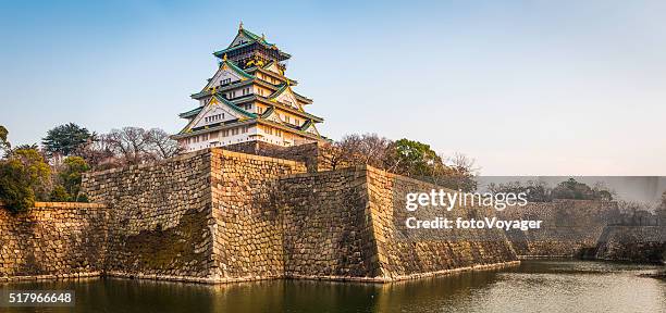 osaka schloss gemäuer und gräben beleuchtet ein sonnenuntergang panorama japan - stadt osaka stock-fotos und bilder