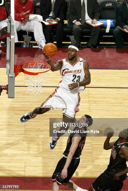 LeBron James of the Cleveland Cavaliers lays one in against Kirk Hinrich of the Chicago Bulls at Gund Arena on November 27, 2004 in Cleveland, Ohio....