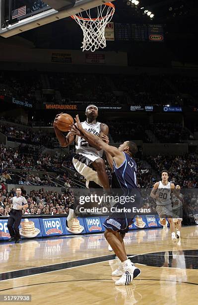 Devin Brown of the San Antonio Spurs drives to the hoop over Howard Eisley of the Utah Jazz during the game at the SBC Center on November 27, 2004 in...