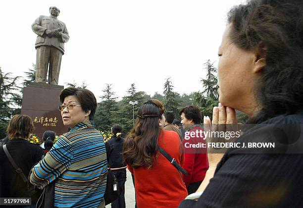 This photo taken 28 October 2004 shows visitors paying their respects to Communist China's former top leader Mao Zedong, facing a statue in Mao's...