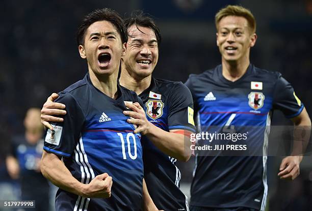 Japan's midfielder Shinji Kagawa celebrates his goal with teammates, forward Shinji Okazaki and midfielder Keisuke Honda , against Syria during the...