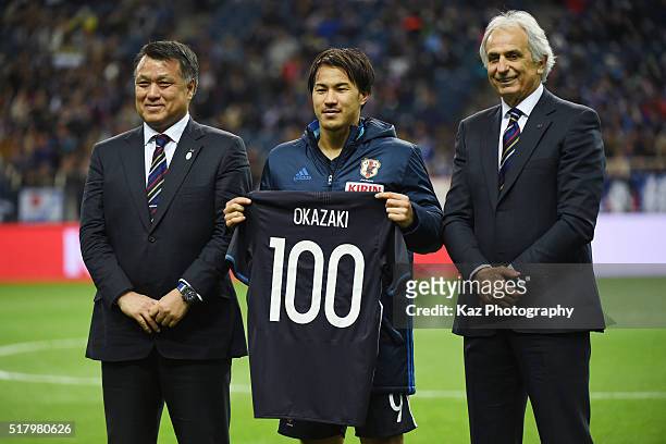 Shinji Okazaki of Japan holds a shirt to mark his 100th appearance for the national team with head coach Vahid Halilhodzic and Japan Football...