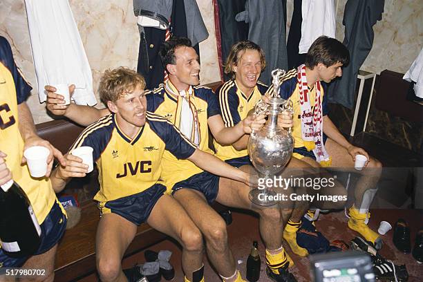 Arsenal players from left Kevin Richardson, Steve Bould, Paul Merson and Alan Smith celebrate in the dressing room with the League Division One...