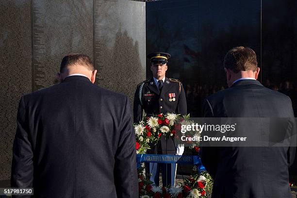 Secretary of Veterans Affairs Robert McDonald and U.S. Secretary of Defense Ash Carter bow their heads during a wreath laying ceremony to commemorate...