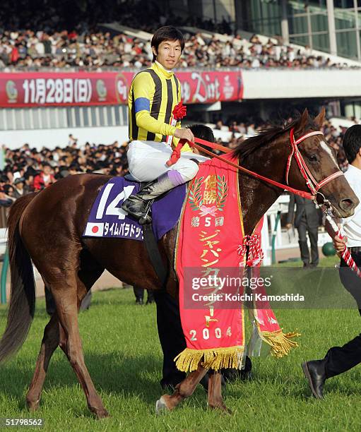 Time Paradox ridden by Japanese jockey Yutaka Take celebrates the victory during the Japan Cup Dirt on November 28, 2004 at Tokyo Race Course in...