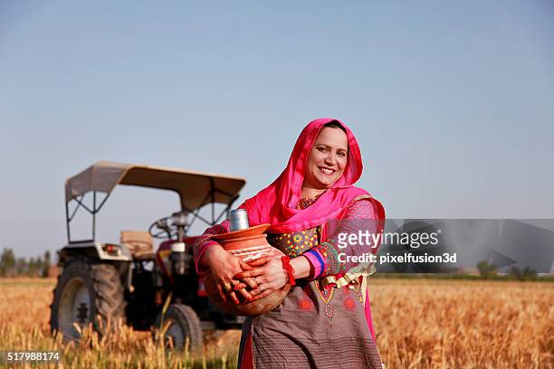 cheerful farmer women carrying water pot - stereotypical homemaker stock pictures, royalty-free photos & images