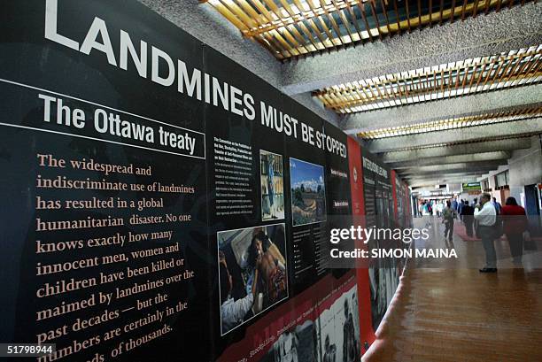 Conference participant looks at posters showing effects of landmines during the opening session of the first review conference of the 1997 Ottawa...