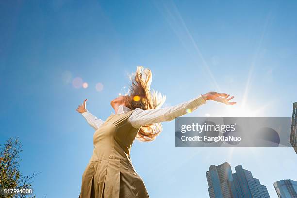 太陽の光の中で外で回転する女の子 - low angle view ストックフォトと画像