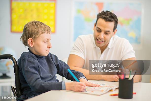 working on a notebook with a tutor - paralysis stock pictures, royalty-free photos & images