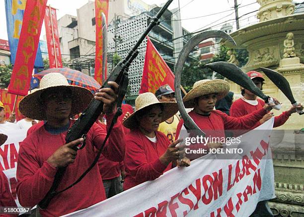 Demonstrators of a labor group dressed as revolutionary "Katipuneros" march to the Malacanang presidential palace in Manila, 29 November 2004 during...