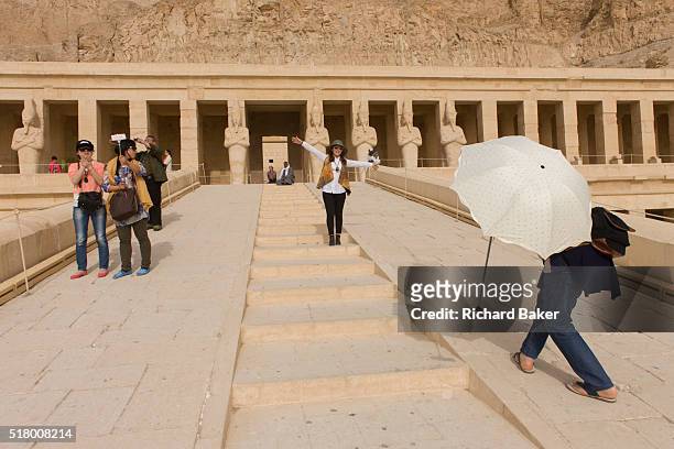 Chinese-speaking tourist group enjoy the experience of visiting the ancient Egyptian Temple of Hatshepsut near the Valley of the Kings, Luxor, Nile...