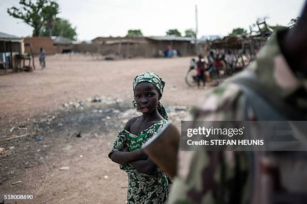 Girl stands crossed arms in an empty market place in Mbalala, Borno State northeast Nigeria on March 25, 2016. On April 14 Boko Haram militants...