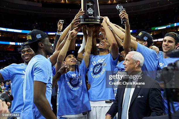 Playoffs: North Carolina Marcus Paige and Brice Johnson victorious, holding East Regional Championship trophy with coach Roy Williams looking on...