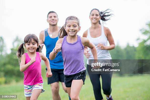 exercising together as a family - family jogging stock pictures, royalty-free photos & images