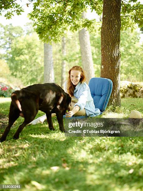 redheaded woman playing with dog - auburn oaks stock pictures, royalty-free photos & images