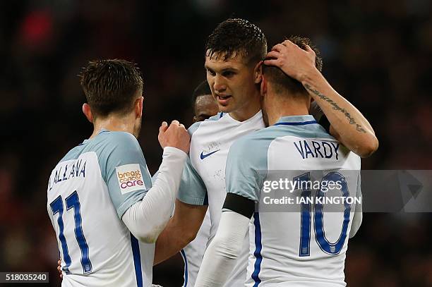 England's midfielder Adam Lallana, England's defender John Stones and England's striker Jamie Vardy celebrate after Vardy scored the opening goal...