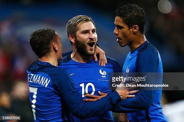 Andre-Pierre Gignac of France celebrates scoring his teams second goal of the game with Antoine Griezmann and Raphael Varane during the International...