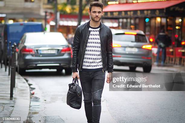 Kevin Ragonneau is wearing a Zara black leather jacket, Zara black jeans, a Brice black bag, a Kapten watch, a Pull and Bear striped top, and Baron...