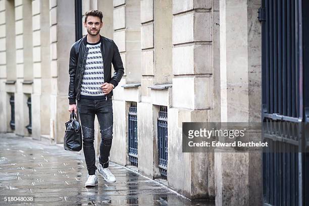 Kevin Ragonneau is wearing a Zara black leather jacket, Zara black jeans, a Brice black bag, a Kapten watch, a Pull and Bear striped top, and Baron...