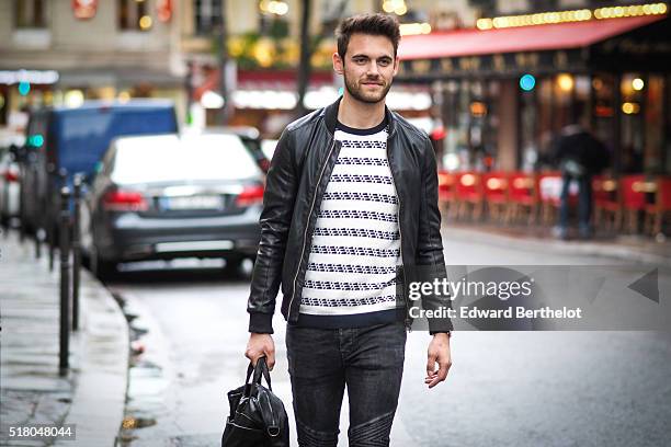 Kevin Ragonneau is wearing a Zara black leather jacket, Zara black jeans, a Brice black bag, a Kapten watch, a Pull and Bear striped top, and Baron...