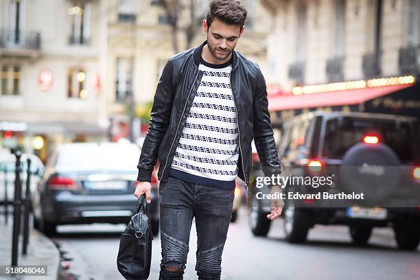 Kevin Ragonneau is wearing a Zara black leather jacket, Zara black jeans, a Brice black bag, a Kapten watch, a Pull and Bear striped top, and Baron...