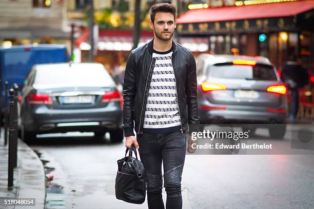 Kevin Ragonneau is wearing a Zara black leather jacket, Zara black jeans, a Brice black bag, a Kapten watch, a Pull and Bear striped top, and Baron...