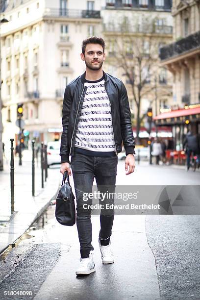 Kevin Ragonneau is wearing a Zara black leather jacket, Zara black jeans, a Brice black bag, a Kapten watch, a Pull and Bear striped top, and Baron...