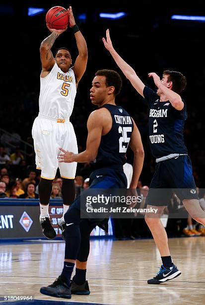 Darien Walker of the Valparaiso Crusaders shoots over Zac Seljaas of the Brigham Young Cougars during their NIT Championship Semifinal game at...