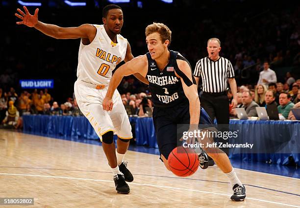 Chase Fischer of the Brigham Young Cougars drives by Keith Carter of the Valparaiso Crusaders during their NIT Championship Semifinal game at Madison...