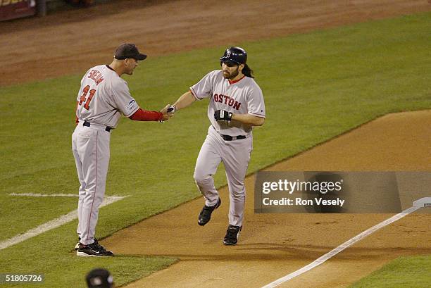 Johnny Damon of the Boston Red Sox is congratulated by third base coach Dale Svuem after hitting a home run in the first inning during game four of...