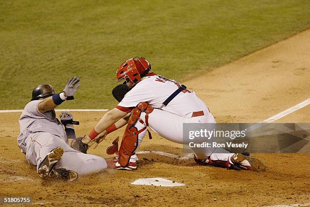 Catcher Yadier Molina of the St. Louis Cardinals tags out Manny Ramirez of the Boston Red Sox at home plate during game four of the 2004 World Series...