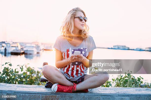 young woman using smart phone on the beach - social media profile stock pictures, royalty-free photos & images