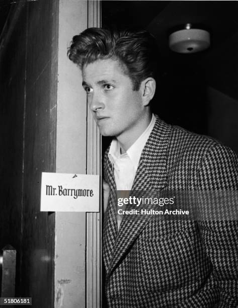 American actor John Drew Barrymore looks through the doorway of his dressing room, early 1950s. Barrymore was the son of American actor John...