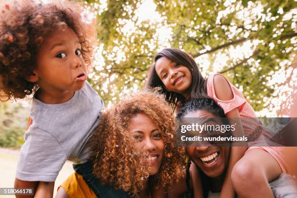 lovely african-american family laughing and making silly faces - quirky family stockfoto's en -beelden