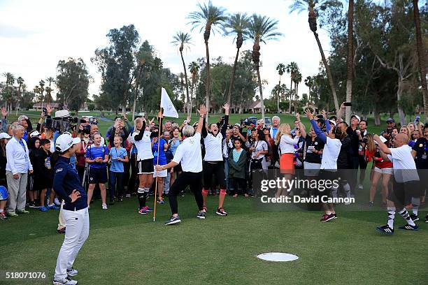 Paula Creamer of the United States celebrates with Abby Wambach of the United States as her 'foot putt' goes into the hole and the other players...