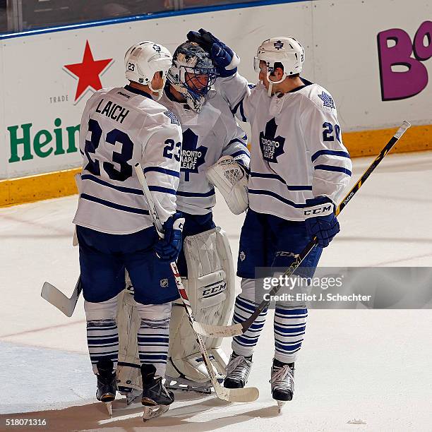 Goaltender Jonathan Bernier of the Toronto Maple Leafs celebrates their win with teammates Brooks Laich and Frank Corrado against the Florida...